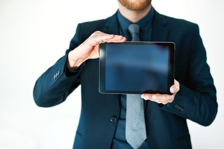 This is just what your business needs. an unrecognizable businessman holding up a digital tablet.の写真素材