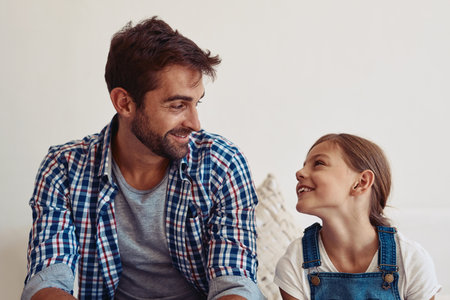 Be someone they can look up to. an adorable little girl spending time with her father at home.の写真素材