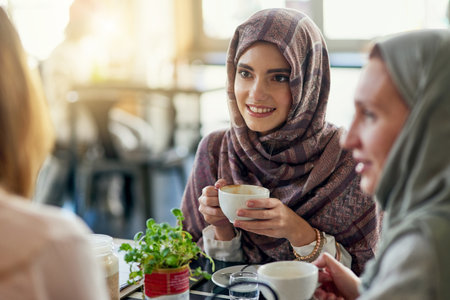 Nothing brings people together like coffee. a group of women chatting over coffee in a cafe.の写真素材