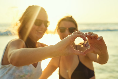 We heart summer. young female best friends hanging out at the beach.の写真素材