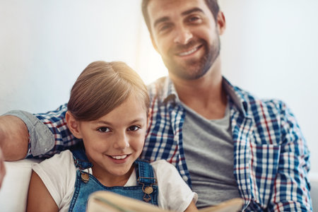 Spending the day side by side. an adorable little girl spending time with her father at home.の写真素材
