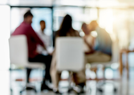 Meeting in progress...Bokeh shot of a group of designers sitting in a meeting in their office.の写真素材
