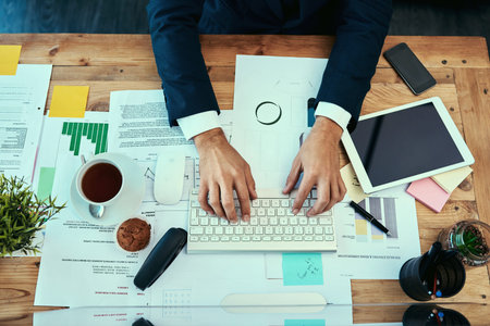 Getting through a productive day. High angle shot of an unidentifiable businessman working on a...