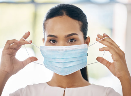 Covid, safety and healthcare with a woman in a mask during the virus outbreak living a new normal lifestyle. Portrait, vaccine and medical with a young female staying safe during the corona pandemicの写真素材