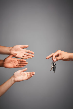 Drivers privileges up for grabs. Studio shot of unidentifiable hands reaching for a set of keys...
