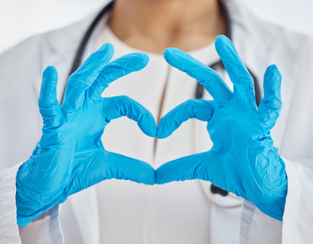 Heart, medical and doctor with hands for support, love and healthcare while working at a hospital. Medicine, care and nurse with gloves and emoji sign for consultation, insurance and cardiologyの写真素材