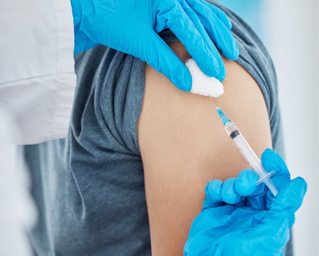 Medicine, needle and patient getting covid vaccine from nurse at medical clinic during pandemic. Medicine, syringe and closeup of healthcare worker doing an antibody vaccination injection at hospitalの写真素材