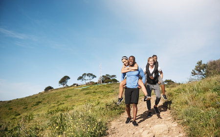 Ill race you to the bottom. two men challenging each other by carrying their girlfriends downhill.