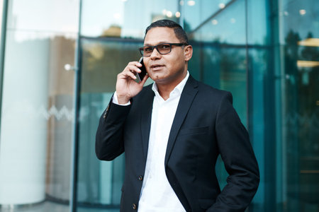 Heading out to meet a client. a handsome mature businessman making a phonecall with his office in...