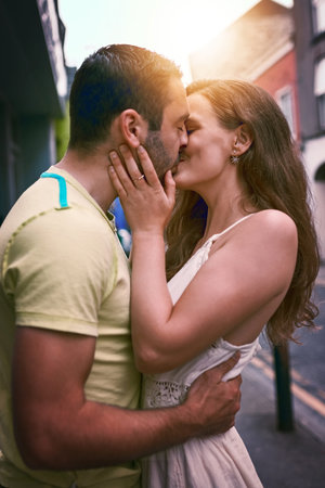 Love is too small a word for what they feel. an affectionate young couple kissing while exploring a...