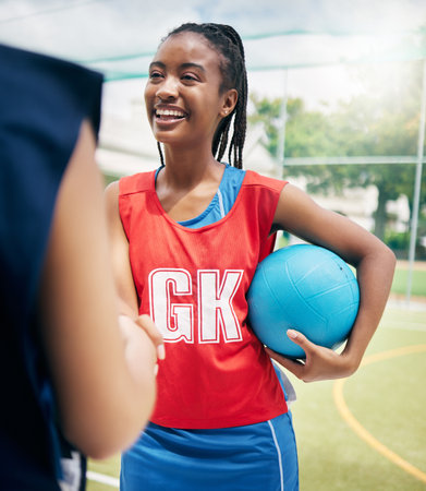 Black woman, netball player and handshake on court in fitness game, workout match or training competition exercise. Smile, happy and sports women in welcome, thank you or good luck gesture in stadiumの写真素材