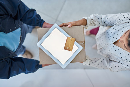 Signed, sealed and delivered. High angle shot of an unrecognizable delivery man handing a package to a female customer.の写真素材