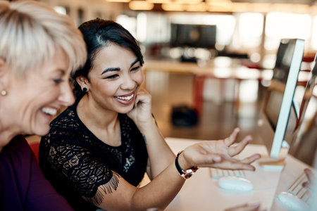 Two of the design industrys best. two businesswomen using a computer together in a modern office.の写真素材