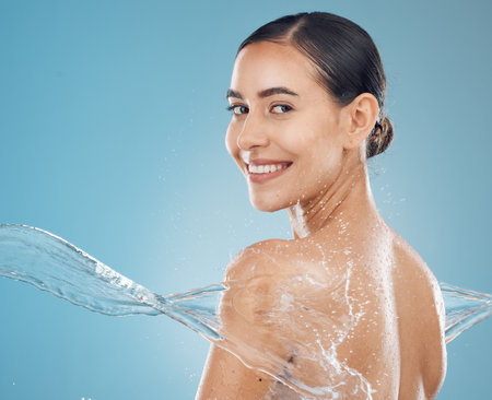 Water, skincare and beauty model splash cleaning skin for body wellness and health from washing. Portrait of a happy and healthy woman from New York with a smile to show happiness and satisfactionの写真素材