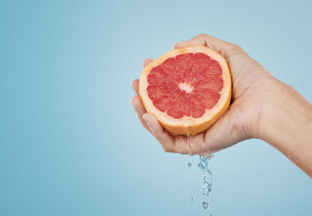 Grapefruit, food and wellness fruit juice of a woman hand with a healthy lifestyle. Model hands with fresh and organic produce for skincare, body and skin health with beauty and cosmetic treatmentの写真素材