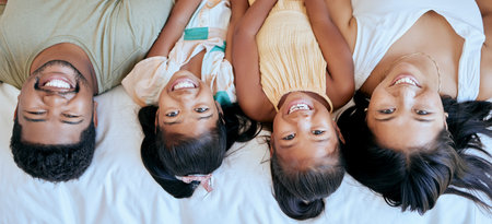 Family, happiness and bedroom playing of mother, father and girl face at home. Portrait of happy parents and children smile in a parent of kid room feeling love, fun and care in a house on a morningの写真素材