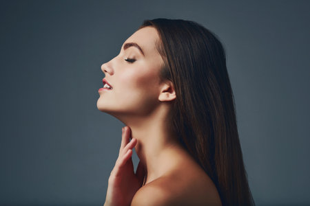 Shes got that flawless skin that everyone desires. Studio shot of a beautiful young woman posing against a blue background.の写真素材