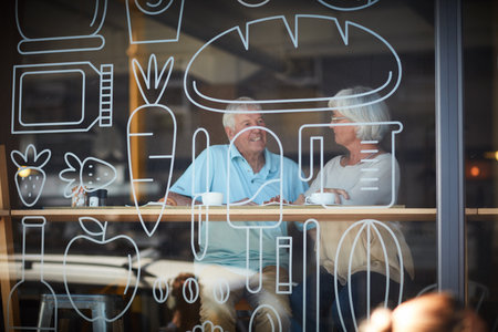 Conversations over coffee. an affectionate senior couple in their local coffee shop.の写真素材