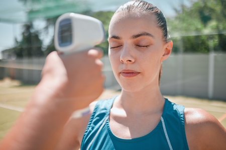 Woman, sports and healthcare test with thermometer for temperature, safety or check on the court outdoors. Active female in sport fitness getting checked for fever or illness with infrared deviceの写真素材