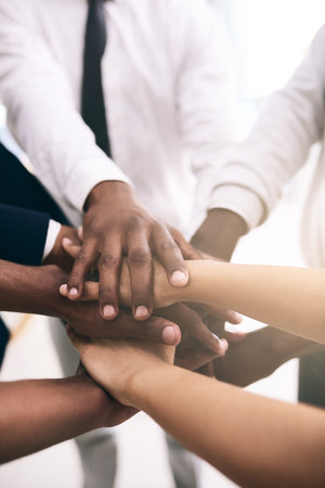 This is for our bright future together as a team. a motivated group of unrecognizable businesspeoples hands forming a huddle.の写真素材