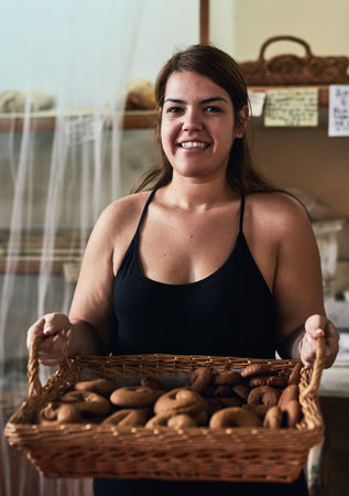They are fresh out of the oven. a young woman working in her bakery.