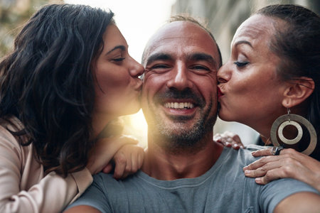 They are all the love I need. two women kissing their male friend on his cheeks.の写真素材