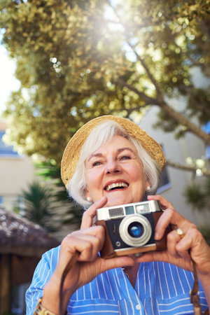 Clicking away but enjoying every moment. a senior woman taking photographs at home.の写真素材