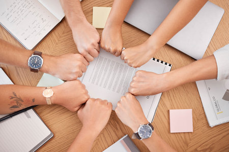 Team hands, business meeting and fist for collaboration or motivation support at office desk....