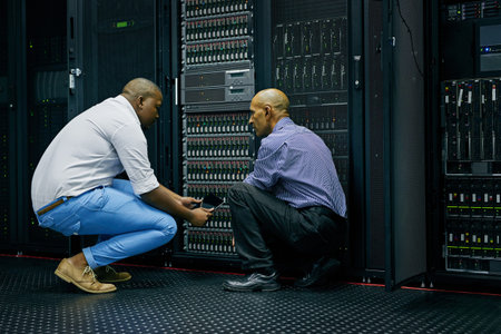 Working efficiently to resolve the issue. two IT technicians repairing a computer in a data center.