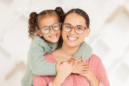 Eye care, glasses and child hug mother with new vision lens, prescription eyeglasses or ocular support spectacles. Eyesight, healthcare service and portrait of happy family at optometry retail storeの写真素材
