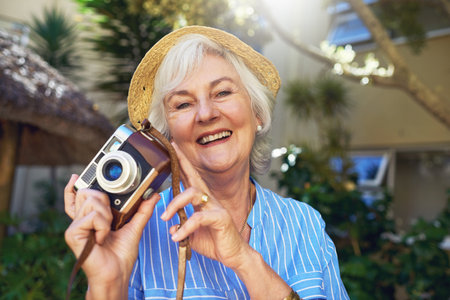 Dont let retirement keep you from capturing the moments. a senior woman taking photographs at home.の写真素材