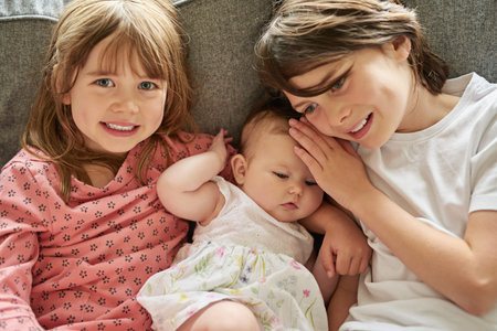 I love my siblings. siblings sitting on a couch together indoors.