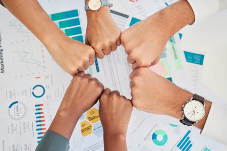 Finance, accounting and team fist bump from above over documents for investing. Teamwork, goal and...