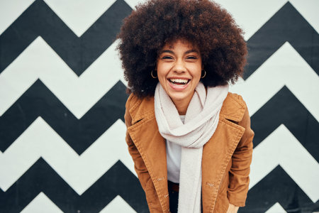 Black woman afro, happy trendy background and smile for beauty, hair care and fashion portrait. Woman, happiness and african hair cheerful by art wall in urban, city or metro for winter clothes styleの写真素材