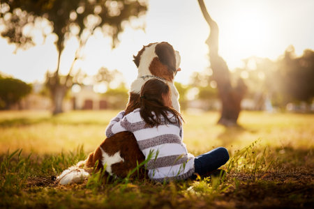 Love is a four-legged word. Rearview shot of a cute little boy hugging her dog while they sit...