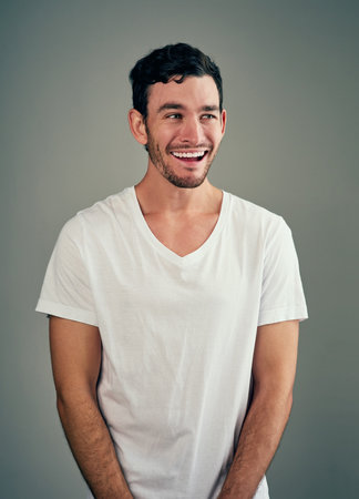 Be happy and smile always. Studio shot of a casual young man posing against a grey background.の写真素材