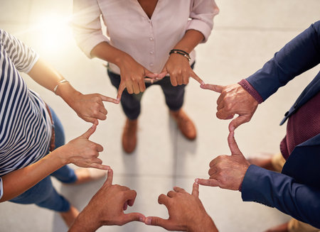 A group of unrecognizable businesspeople joining their hands in a gesture of unity.