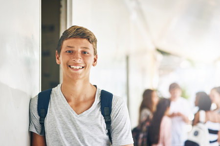 School is my favourite place to be. Portrait of a happy schoolboy standing outside his classroom...