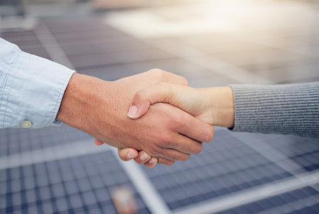 Handshake, welcome and b2b with a business man and woman shaking hands at a solar power plant....