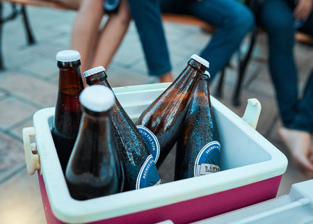Ice cold beers all party long. bottled beers chilling in a cooler box at an outdoor gathering.の写真素材
