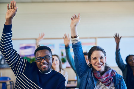 We all want more in life. a group of students raising their hands in class.の写真素材