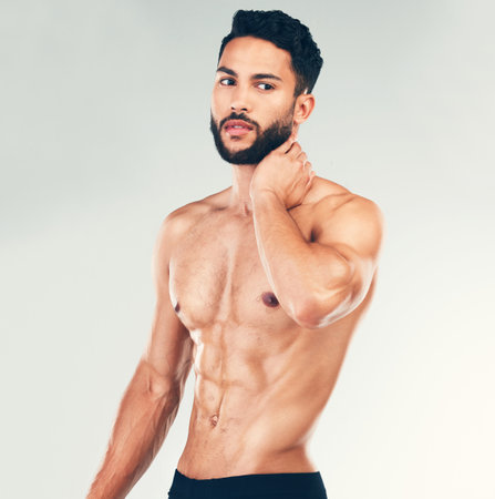 Bodybuilder, strong and topless man showing his abs and fit body on a stufio background. Fitness, shirtless handsome young man and posing for strength, muscle and bodybuilding or weightliftingの写真素材
