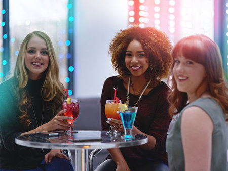 Fri-yay. Portrait of a group of happy friends enjoying cocktails in a nightclub.の写真素材