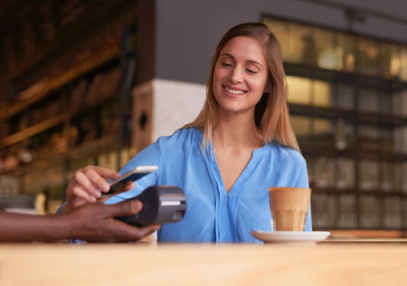 Another satisfied customer. an attractive young woman making payment in a coffee shop.