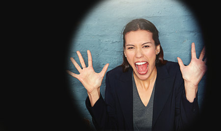 Too much excitement to contain. Portrait of a businesswoman posing against a brick wall with a peephole effect.の写真素材