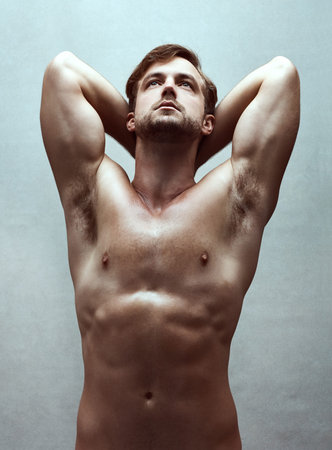 A handsome bare-chested young man posing in the studio.の写真素材