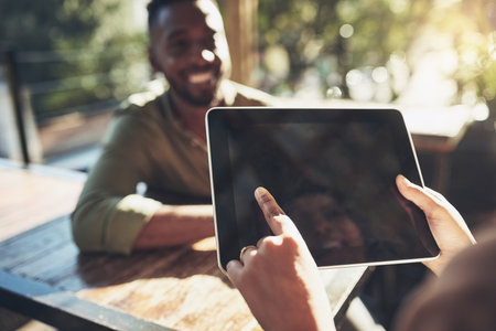 A young man placing his order with a waiter using a digital tablet.の写真素材