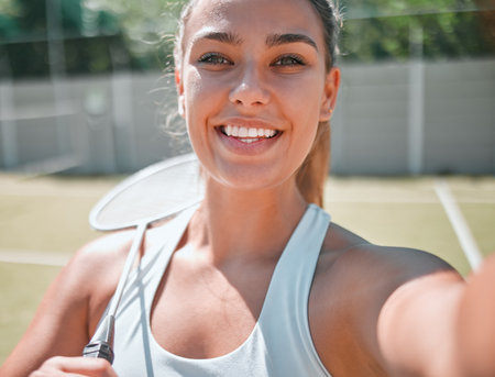 Woman, athlete with tennis selfie for fitness outdoor on tennis court, happy in picture and ready for sport game. Sports, smile with tennis racket and active lifestyle, healthy and exercise portrait.の写真素材