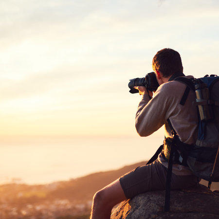 Time spent in nature is never wasted. a young photographer taking a picture from the top of a...