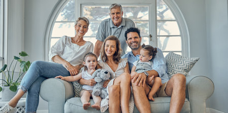 Happy family, portrait and relax on a sofa with happy, smile and cheerful people in their home together. Love, family and kids with parents and grandparents in a living room, bond and laugh on couchの写真素材